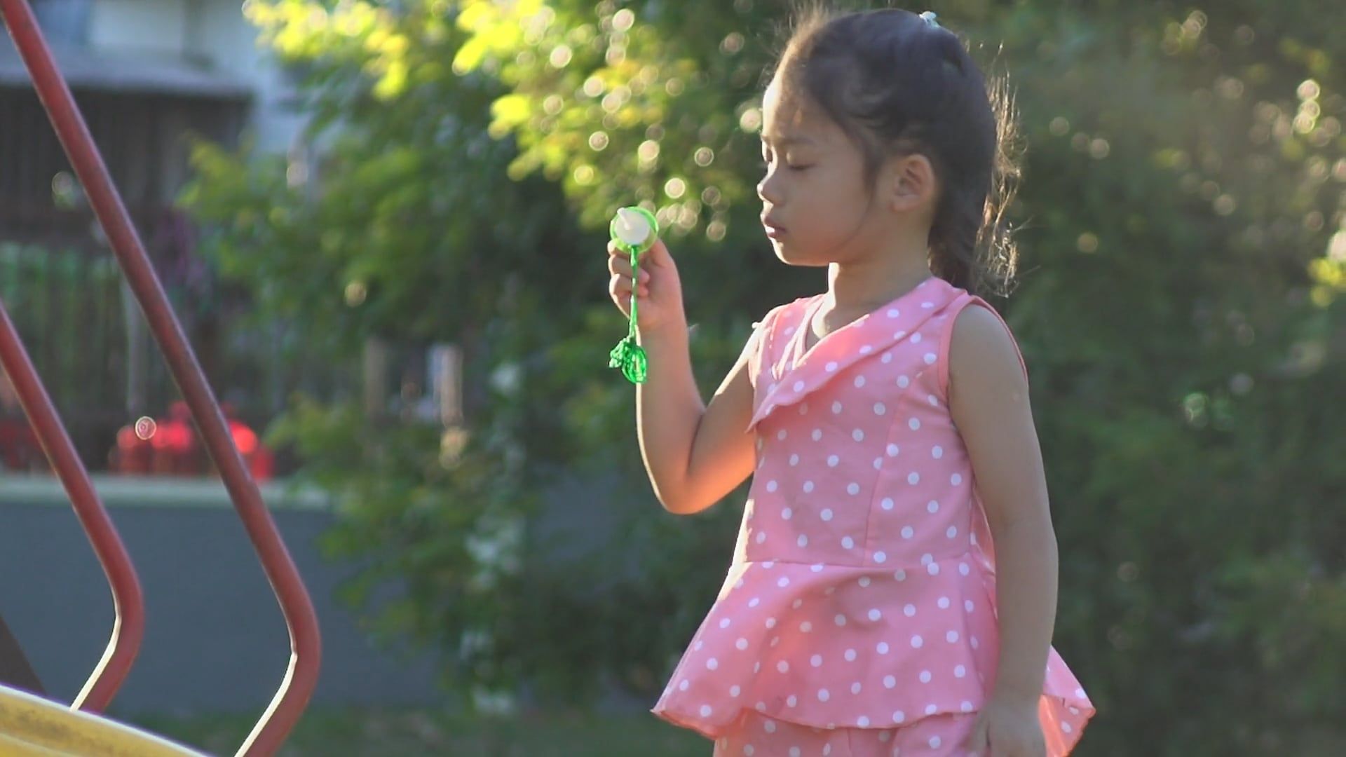 Adorable girl blowing bubbles outdoors in a sunny park, 28s, 16:9